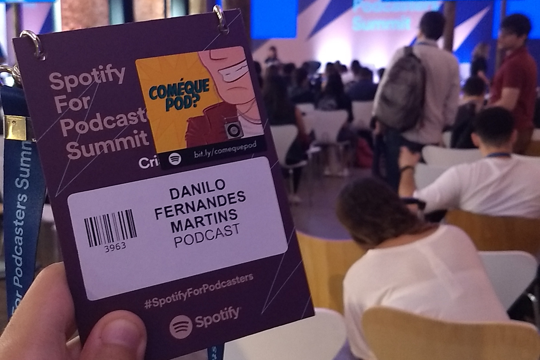 Crachá do evento do Spotify em minhas mãos e um palco ao fundo